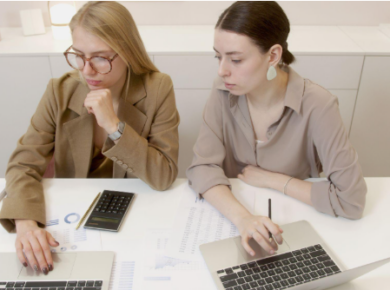 two women with laptops
