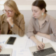 two women with laptops